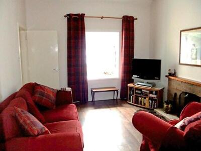 ArnisdaleBrightwater Cottage的客厅配有红色沙发和电视