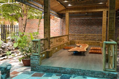 宁平City Garden Hostel的一个带桌子、长椅和砖墙的庭院