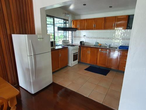 苏瓦Loverly 3 Bedroom rental pool outdoor area的厨房配有白色冰箱和木制橱柜。