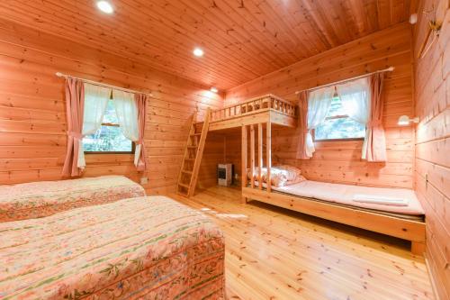 嬬恋村书林酒店的小木屋卧室设有两张床和窗户