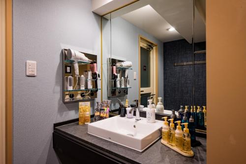 横滨Hotel WILL BASE 旧Chambery的浴室设有白色水槽和镜子