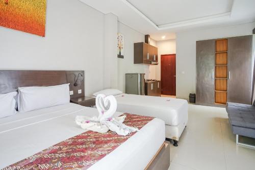 沙努尔阿卡萨特兰西特酒店的酒店客房,设有两张带带丝带的床
