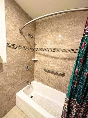 BellTropic West Motel的浴室配有白色浴缸和淋浴。