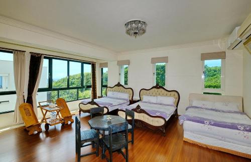 Dahan花莲七星潭海湾民宿的一间卧室设有两张床、一张桌子和窗户。