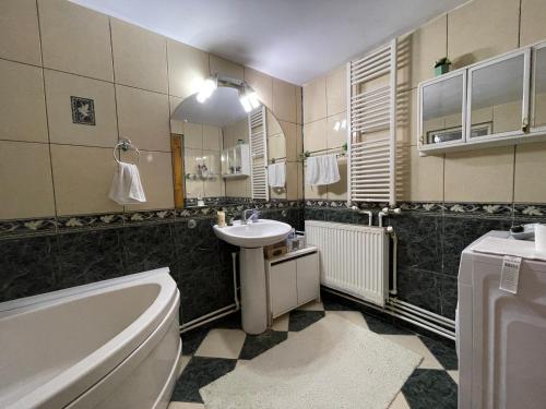 克拉约瓦Ada-Ini House的浴室配有盥洗盆、卫生间和浴缸。