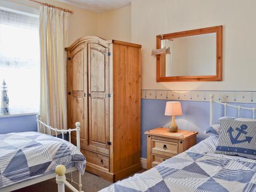 弗兰伯勒科布尔乡村别墅的一间卧室配有一张床、梳妆台和镜子