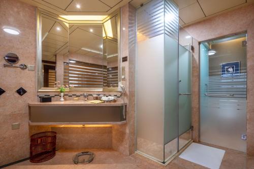 宝安深圳宝利来国际大酒店(宝安,福永)的一间带玻璃淋浴和水槽的浴室