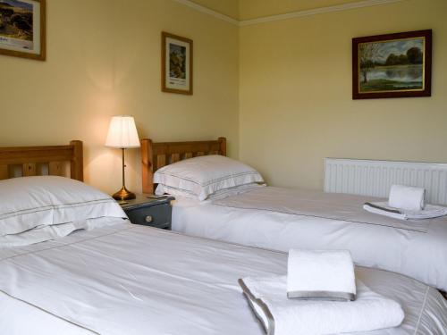 里伯斯谷地霍顿三峰度假屋的配有白色床单的客房内的两张床