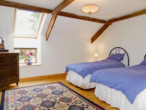 MilfieldTill Cottage的一间带两张床的卧室和地毯