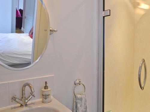 莫法特Roseburn Cottage的一间带水槽和镜子的浴室以及一张床