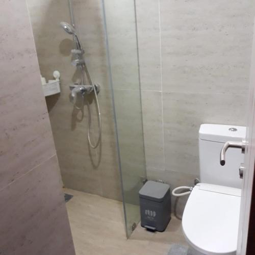 JurangmangguThe Accent Apartemen的带淋浴、卫生间和垃圾桶的浴室