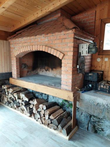 BarilovićVILLA KORANA的一个带桌子和木柴的室外砖炉