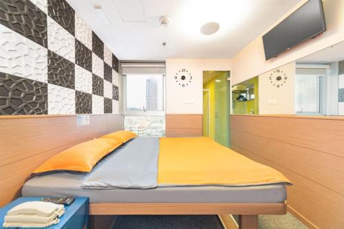 香港香港奥斯酒店的卧室配有一张床铺,墙上配有电视
