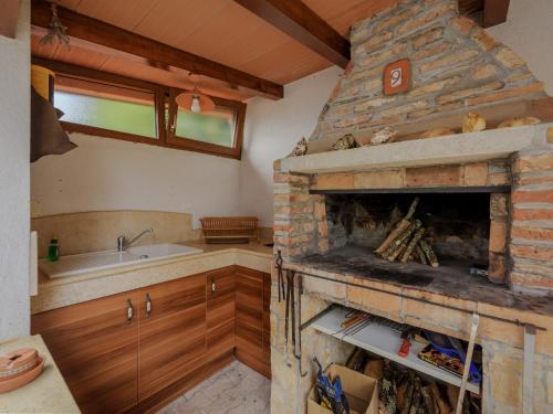 波雷奇Casa Astrid的厨房设有石制壁炉和水槽。