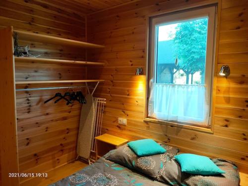 鲁斯诺沃Wakacyjne Zacisze的小木屋内一间卧室,配有一张床和一个窗户