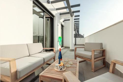 塞维利亚Uxama Sevilla Luxury Penthouse en Triana - Terraza y parking privados - piscina的客厅配有沙发和桌子