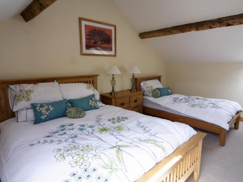 纽敦Cefnaire Isaf的一间卧室配有两张单人床和白色床单