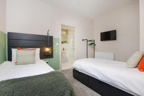 普里茅斯Apartment Three - Free Private Car Park - sleeps 6 - 3 shower rooms - by Ocean City Retreats的卧室内两张并排的床