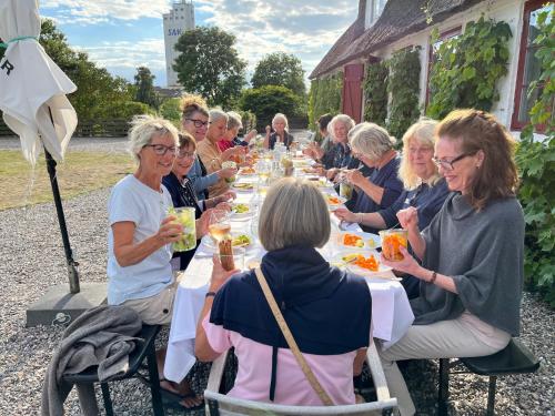 BallenKøbmandsgården的一群坐在长桌旁吃饭的人