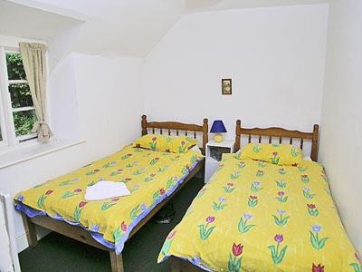 WithycombeTacker Street Cottage的两张睡床彼此相邻,位于一个房间里