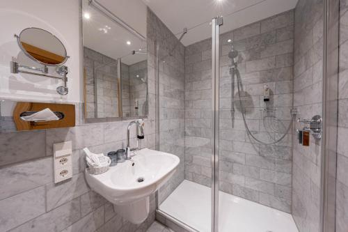 诺德奈洛吉尔豪斯拉特豪斯酒店的白色的浴室设有水槽和淋浴。
