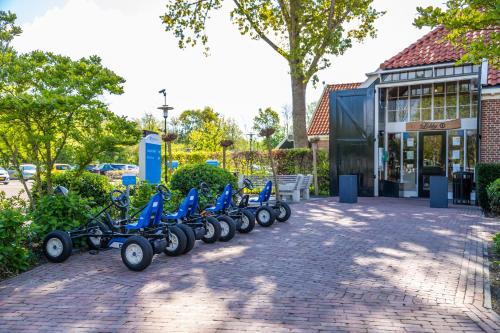 费尔森-需德Comfort Rooms by EuroParcs Buitenhuizen的停在大楼前的一排蓝色摩托车
