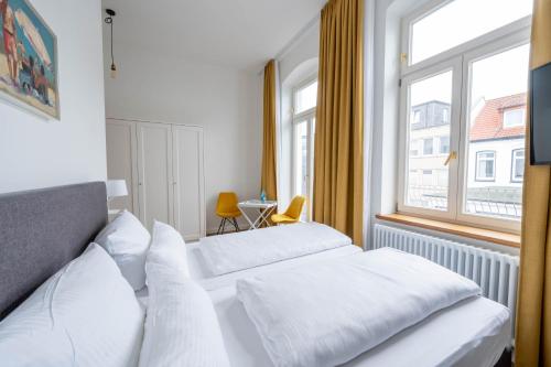 诺德奈洛吉尔豪斯拉特豪斯酒店的配有窗户的酒店客房内的两张床