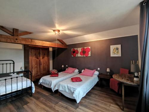 Braye-sous-FayeAux Acacias的一间卧室配有两张带红色枕头的床