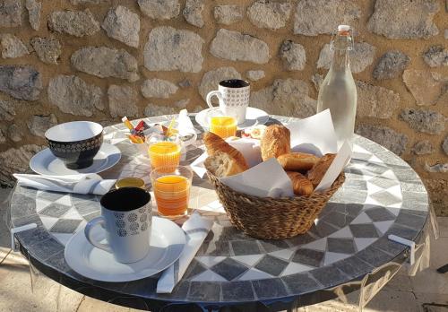 Conne-de-LabardeChambre d'hôte La Pierre的一张桌子,上面放着一篮面包和一瓶牛奶