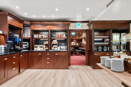 松达尔兰格西佳酒店的一间带木制橱柜的厨房和一间用餐室
