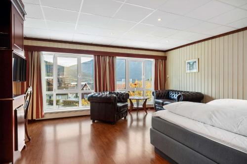 松达尔兰格西佳酒店的酒店客房设有床、椅子和大窗户。