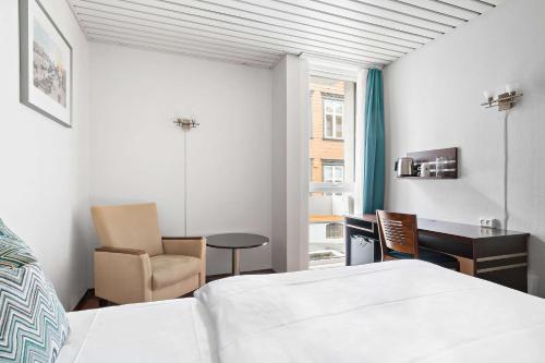 斯塔万格Havly Hotell的一间卧室配有一张床、一张桌子和一把椅子