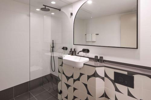 悉尼The Capitol Hotel Sydney的一间带水槽和镜子的浴室