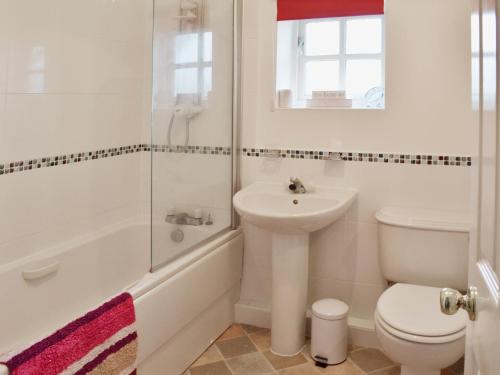 斯卡伯勒Beach Walk Cottage的白色的浴室设有水槽和卫生间。