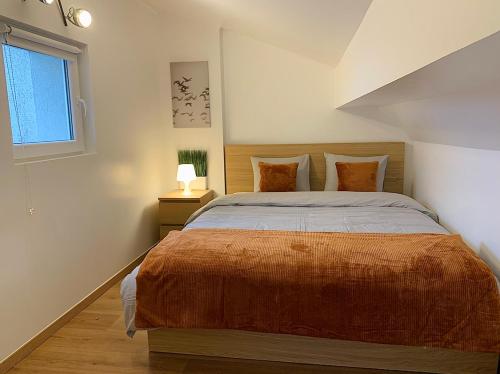 阿尔泽特河畔埃施Esch/Alzette city apartment的一间卧室配有一张带橙色毯子的大床