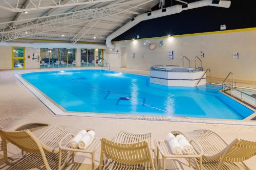 伊斯特雷格假日南安普敦伊斯特利酒店的一个带椅子的大型游泳池以及一个大型游泳池