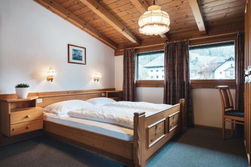 圣维吉利奥加尼伊索克酒店的一间卧室设有一张木床和一个窗户。