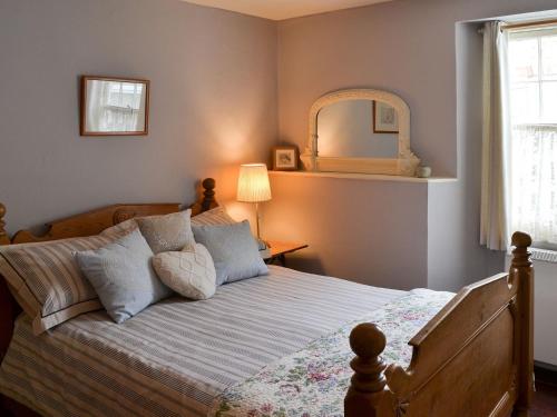 Polruan费尔梅登乡村别墅的卧室配有一张壁挂镜子的床