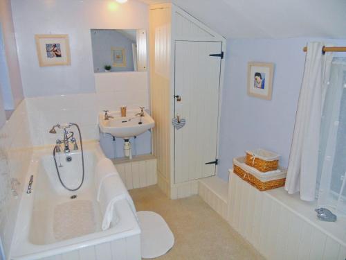 Polruan费尔梅登乡村别墅的带浴缸、水槽和浴缸的浴室