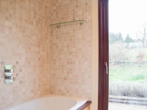 AymestreyThe Wooden Lodge的带浴缸的浴室和窗户