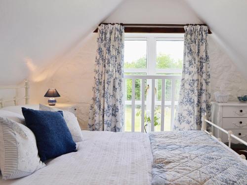 AuchnastankWoodside Cottage的一间卧室设有一张床和一个大窗户