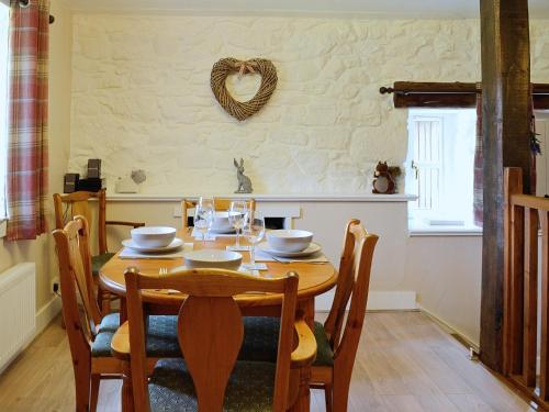AuchnastankWoodside Cottage的用餐室配有木桌和椅子