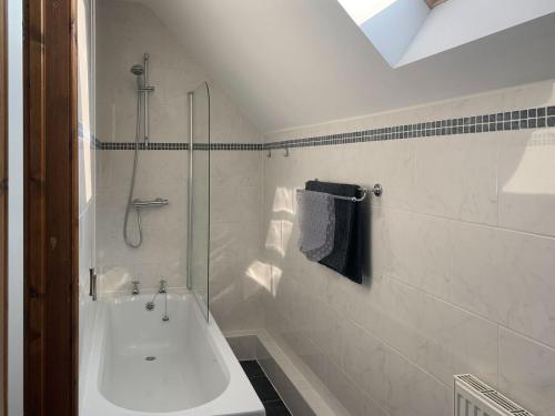 North Somercotes格兰纳里度假屋的白色的浴室设有淋浴和浴缸。
