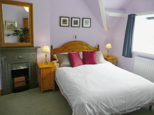 瓦特米尔洛克园丁乡村别墅的一间卧室配有带白色床单和红色枕头的床。
