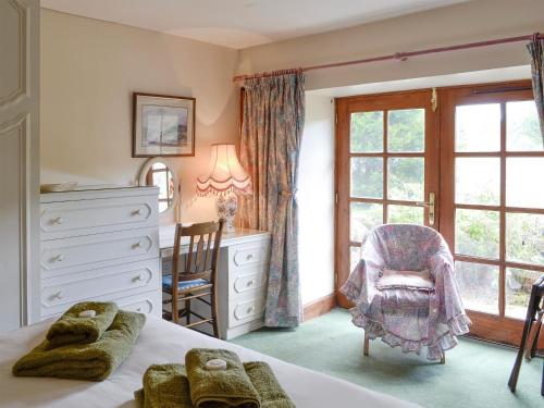 TulchanRowan Tree Cottage - S4216的一间卧室配有一张床、一个梳妆台和一扇窗户。