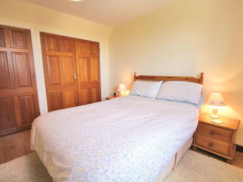 奇平索德伯里Fox Cottage - E4510的一间卧室配有一张床和两个木制橱柜。