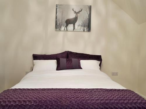 布伦特山庄Hollys Barn的卧室配有一张挂着鹿图的床铺。