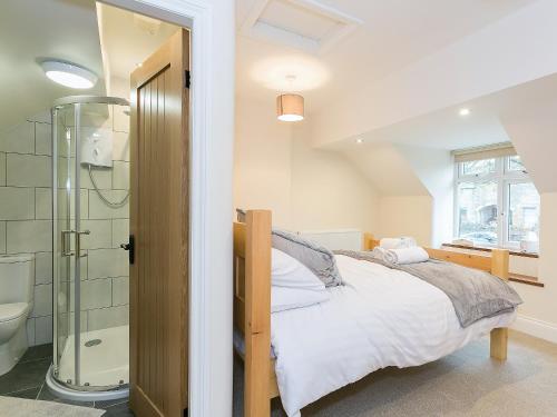 泰德斯韦尔Manor Cottage的一间卧室配有一张床和淋浴