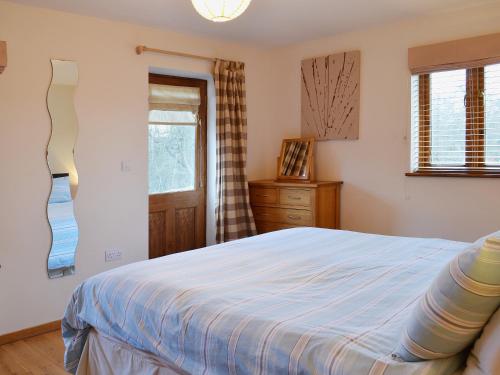 Bearsted马厩乡村别墅的一间卧室配有一张床、一个梳妆台和一扇窗户。