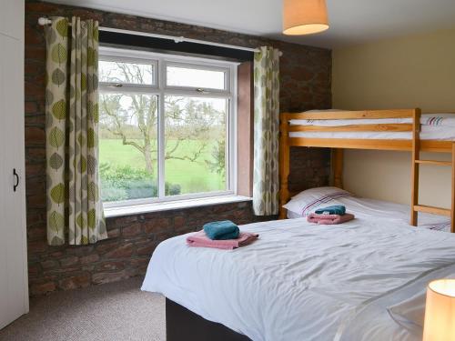 BlencogoBlaithwaite Stables的一间卧室设有两张双层床和一扇窗户。